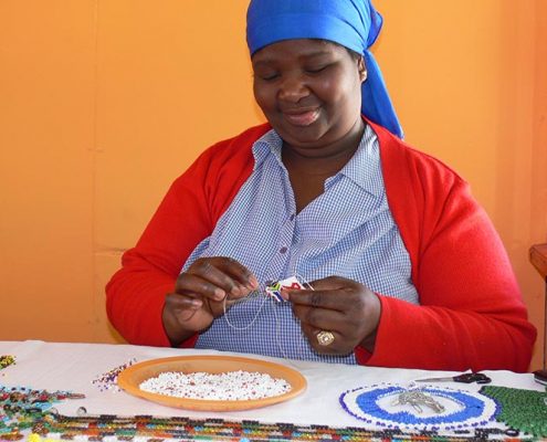 A woman making beaded jewelry at Khayelitsha craftmarket